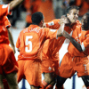 Romeo Castelen (rechts) viert een doelpunt van Oranje met Rafael van der Vaart en Nigel de Jong