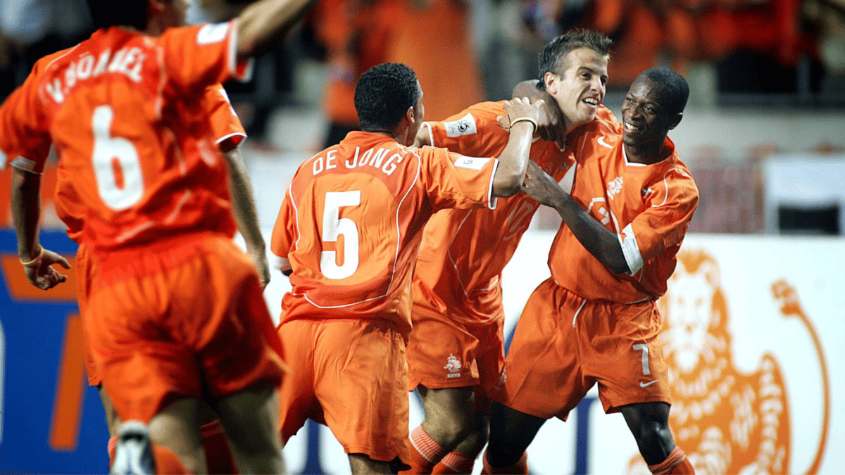 Romeo Castelen (rechts) viert een doelpunt van Oranje met Rafael van der Vaart en Nigel de Jong