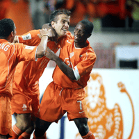 Romeo Castelen (rechts) viert een doelpunt van Oranje met Rafael van der Vaart en Nigel de Jong