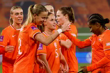 Lynn Wilms en Lineth Beerensteyn vieren een goal van de Oranje Leeuwinnen