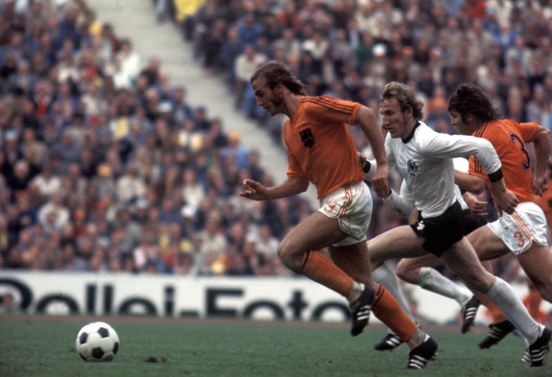 George Schwarzenbeck van West-Duitsland in gevecht met Johan Neeskens (links) en Wim van Hanegem (rechts) tijdens de WK-finale van 1974
