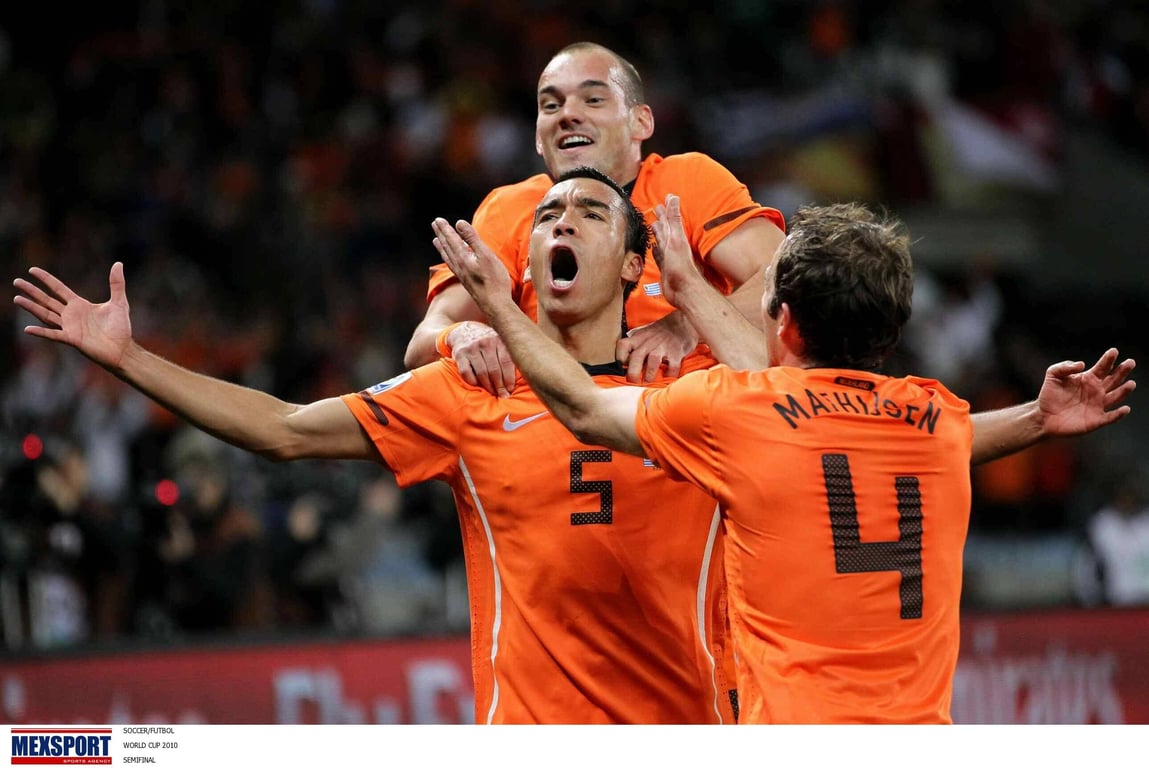 Giovanni van Bronckhorst, Joris Mathijsen en Wesley Sneijder vieren doelpunt tijdens de halve finale tegen Uruguay. 