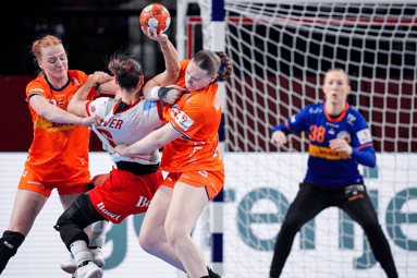 De handbalvrouwen doen er alles aan om een doelpunt te voorkomen