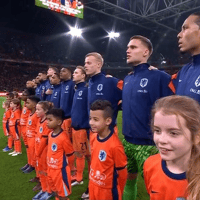 De spelers van het Nederlands elftal luisteren naar het volkslied