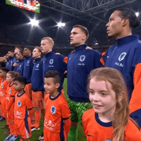 De spelers van het Nederlands elftal luisteren naar het volkslied