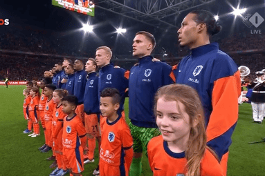 De spelers van het Nederlands elftal luisteren naar het volkslied